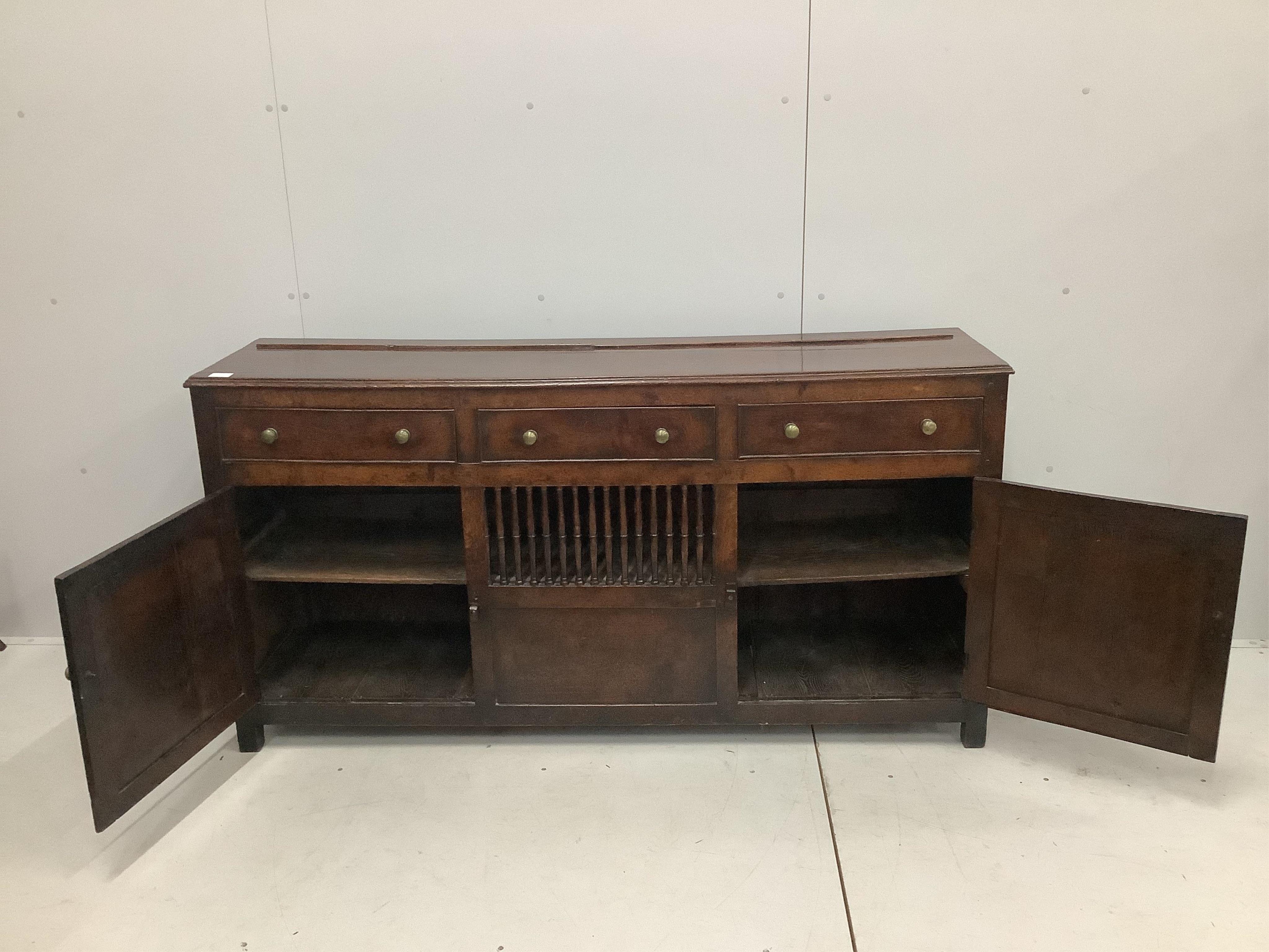 An 18th century North Wales oak enclosed dresser with central spindled glass or food compartment, width 163cm, depth 43cm, height 84cm. Condition - light wear but essentially good. Purchased from the specialist oak deale